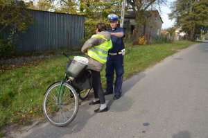 policjanci rozdają kamizelki odblaskowe mieszkańcom