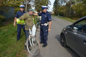 policjanci rozdają kamizelki odblaskowe mieszkańcom