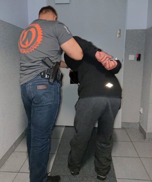 policjant prowadzi zatrzymanego