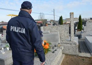 Policjant stojący przy cmentarzu