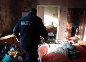 policjant umundurowany stoi w opuszczonym mieszkaniu