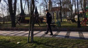 umundurowana policjantka spaceruje obok parków rozrywki