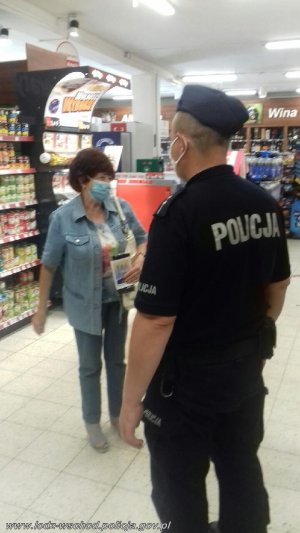 umundurowany policjant wchodzi do sklepu i jest w jego wnętrzu