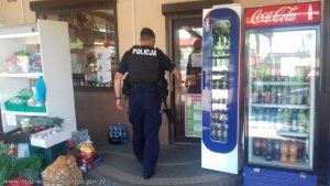 umundurowany policjant wchodzi do sklepu i jest w jego wnętrzu