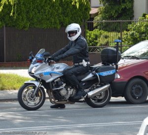policjant w białym kasku na motorze