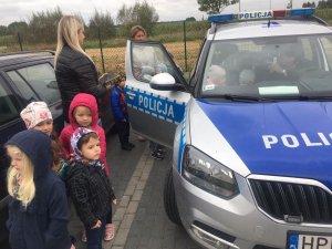 dzieci stoją przy radiowozie policyjnym