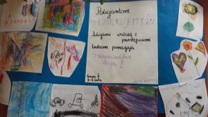 Kartka z podziękowaniami dla policjantów za ich pracę a wokół niej kolorowe rysunki od przedszkolaków
