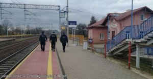 Umundurowani policjanci idą na dworcu kolejowym
