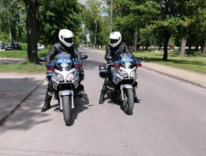 policjanci w białlych kaskach siedzą na motocyklach oznakowanych