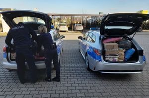 policjantka i policjant pakują zgromadzone dary do radiowozów