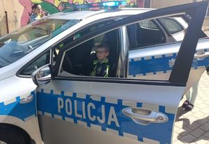 policjanci rozmawiają z przedszkolakami i pokazują im radiowóz