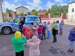 Policjantka opowiada dzieciom o swojej pracy i pokazuje sprzęt służbowy