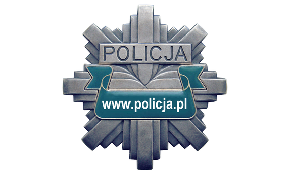 Odznaka policyjna w kształcie gwiazdy koloru szarego na środku wytłoczony napis policja i na zielonym pasku napis policja pl.