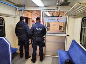 Policjant i strażnik ochrony kolei stoją w pociągu.