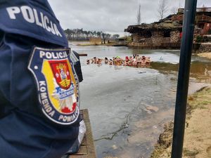 Naszywka na mundurze z napisem Komenda Powiatowa Policji na tle ludzi będących w wodzie.