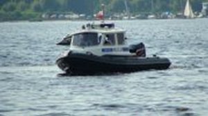 Policyjna motorówka płynie po wodzie i patroluje obiekt wodny