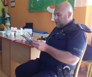 Policjant czyta wiersze przedszkolakom i rozmawia z nimi o bezpieczeństwie