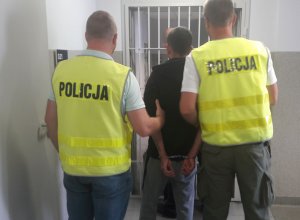 Policjanci prowadzą zatrzymanych
