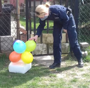 policjanci dostarczają tort urodzinowy dla dziewczynki przebywającej na kwarantannie