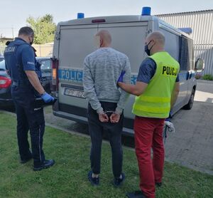 Policjanci prowadzą zatrzymanych mężczyzn.