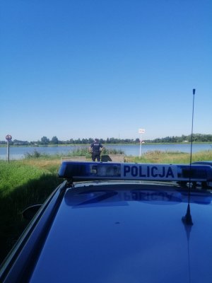 Radiowóz policyjny nad wodą.