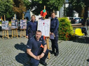 Policjanci stoją przy plakacie.