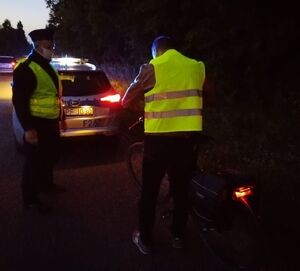 Dzielnicowy rozdaje kamizelki odblaskowe mieszkańcom.