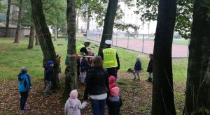 Policjanci pokazują przedszkolakom jak właściwie zachowywać się na drodze i przez nią przechodzić.