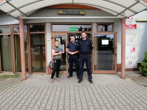 Policjanci stoją przed komisariatem z dziennikarką i pozują do zdjęcia.
