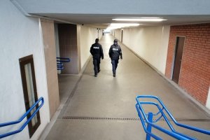 Policjant i policjantka umundurowani patrolują idąc pieszo ulicami, skwerami i peronami dworca kolejowego czy wszyscy przestrzegają obostrzeń.