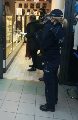umundurowani policjanci wchodzą do sklepów razem z pracownikami sanepidu