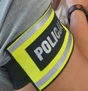 opaska na ramieniu z napisem Policja