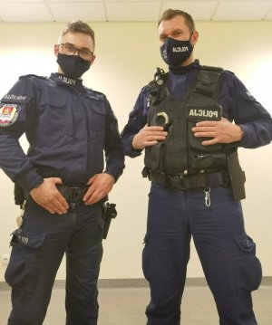 dwaj umundurowani policjanci, maja maseczki na twarzy