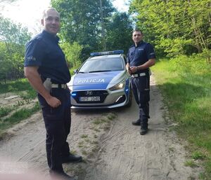 policjanci stoją przy radiowozie