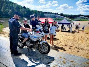 policjanci i strażacy na spotkaniu z młodzieżą przy zbiorniku wodnym na plaży