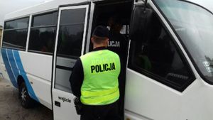 Policjanci stoją przy dzieciach wchodzących do autobusu szkolnego
