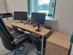 nowe pomieszczenie służbowe wyposażone w biurko, komputery, usytuowane przy wejściu do budynku