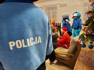 policyjne maskotki wraz z mikołajem i policjantką na spotkaniu z dziećmi