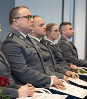 policjanci siedzą na krzesłach ustawionych w rzędzie