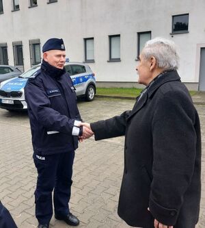 Starosta przekazuje kluczyki do samochodu policjantom stojącym obok niego.
