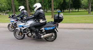 Dwóch policjantów jedzie na policyjnych motocyklach.