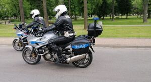 Dwóch policjantów jedzie na policyjnych motocyklach.