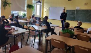 Policjantka stoi na środku sali, przed nią siedzi grupa młodych osób.