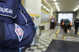 Ramię policjanta na tle stacji diagnostycznej.