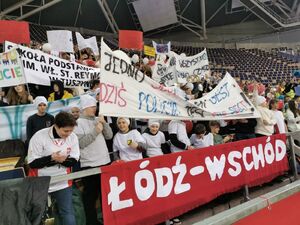 Uczniowie na trybunach z transparentami.