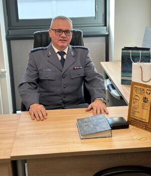 Kierownik posterunku siedzi za biurkiem.