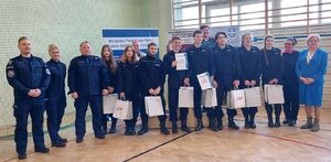 Drużyny uczniów stoją obok siebie, przy nich są ustawieni nauczyciele i policjanci.