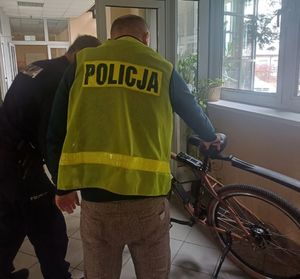 Dwóch policjantów stoi przy rowerze.