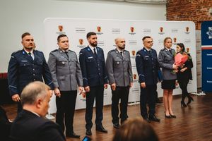 Policjanci i policjantka stoją obok siebie w rzędzie.