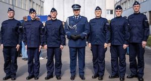Policjanci i policjantka stoją obok siebie w rzędzie.
